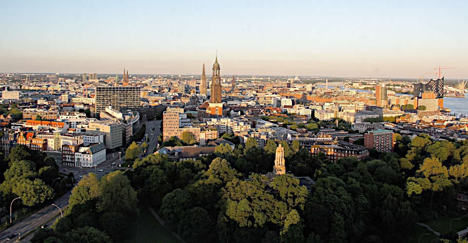 Blick auf Hamburg, in der Mitte der "Michel", rechts Hafen mit Elbphilharmonie, im Vordergrund ein Park mit Bismarckdenkmal