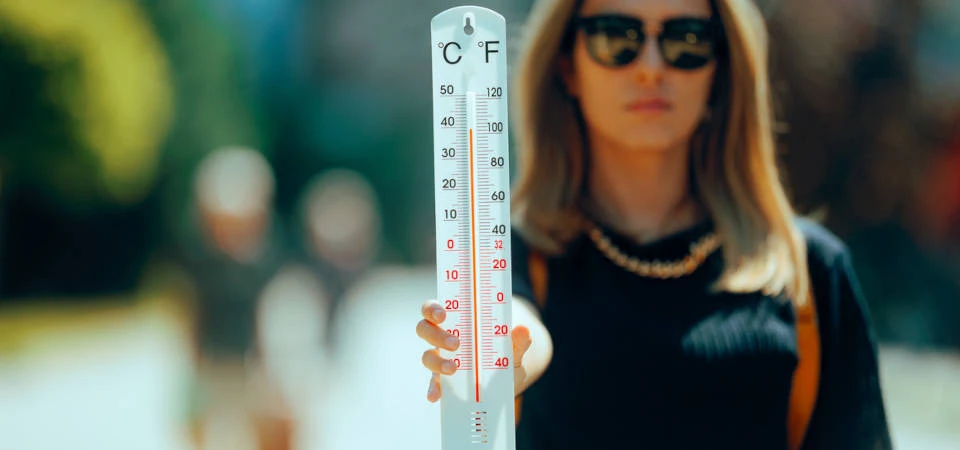 Eine Frau zeigt ein Thermometer