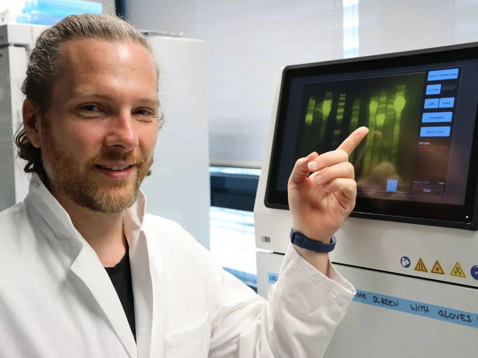 Andrew O’Donnell weist auf den Monitor des Gel-Bildgebungssystem